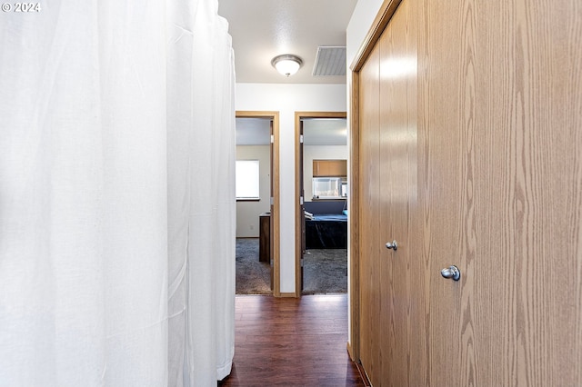 corridor featuring visible vents and dark wood finished floors