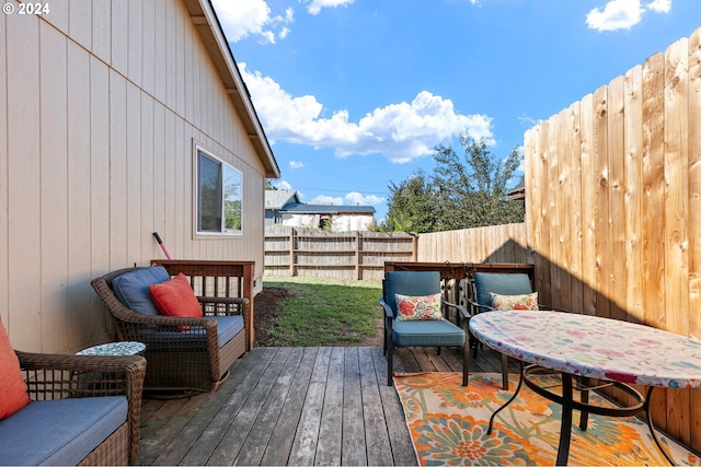 wooden deck with a fenced backyard