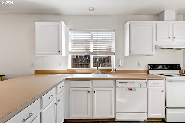 kitchen featuring white appliances, white cabinets, under cabinet range hood, and a sink