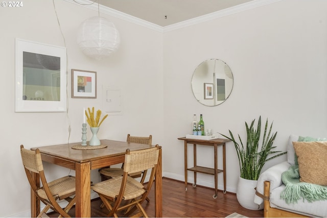 dining space with dark hardwood / wood-style flooring and crown molding