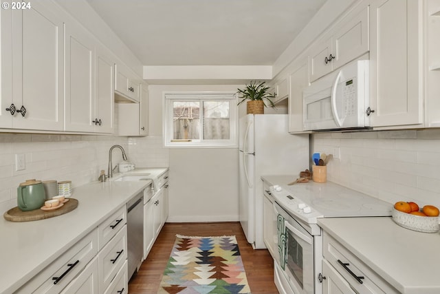 kitchen with dark hardwood / wood-style flooring, decorative backsplash, sink, white cabinetry, and white appliances