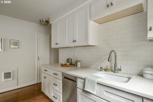 kitchen with white cabinets, hardwood / wood-style floors, dishwasher, sink, and backsplash