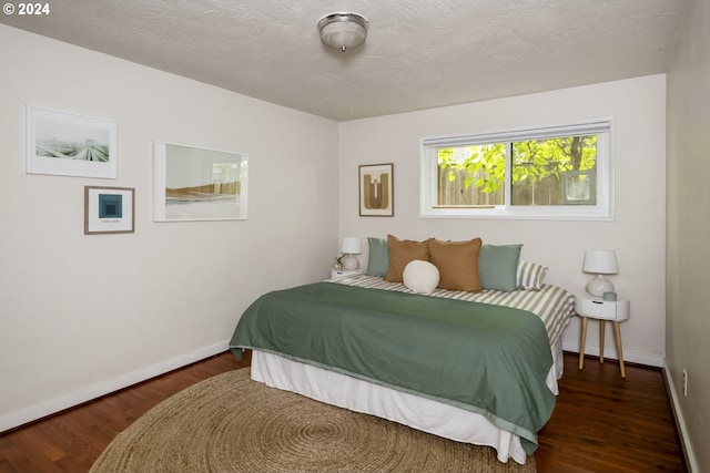 bedroom featuring dark hardwood / wood-style floors and a textured ceiling