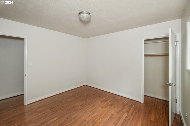 unfurnished bedroom featuring hardwood / wood-style flooring and a closet