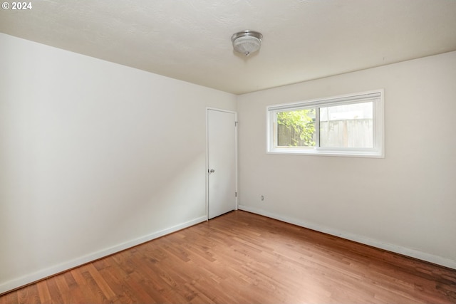 spare room featuring wood-type flooring