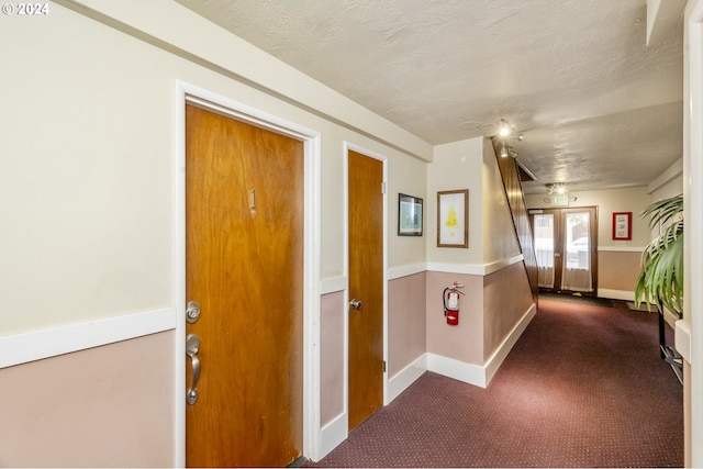 821 SE 29th Ave Unit 1, Portland, OR 97214 - hallway with dark colored carpet, baseboards, and a textured ceiling