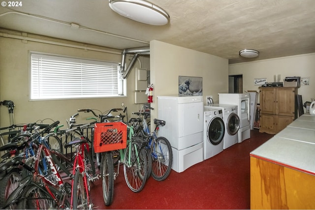 clothes washing area with separate washer and dryer and cabinets