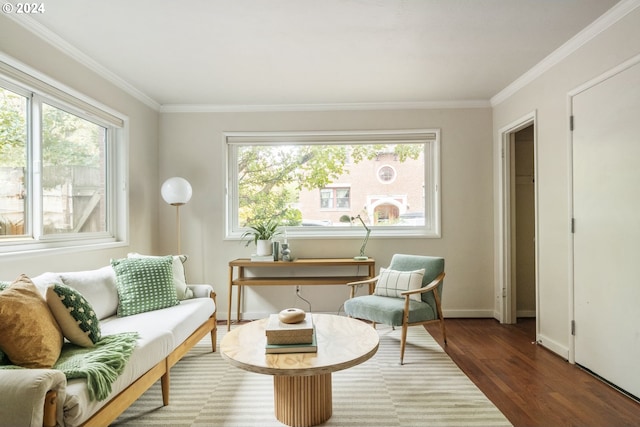 sitting room with dark wood-type flooring, a healthy amount of sunlight, and ornamental molding