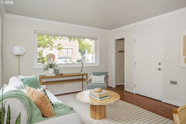 sitting room with dark wood-type flooring and crown molding