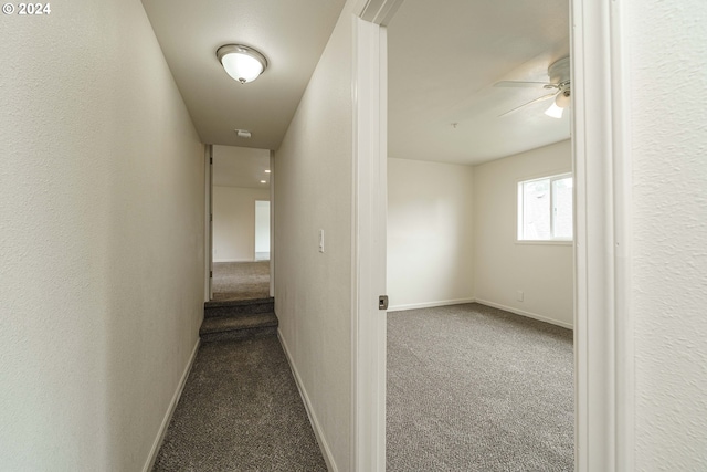 corridor featuring dark colored carpet