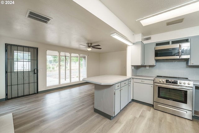 kitchen with light hardwood / wood-style flooring, kitchen peninsula, ceiling fan, stainless steel appliances, and decorative backsplash