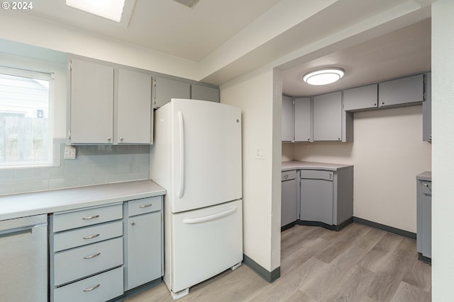 kitchen featuring gray cabinetry, backsplash, white appliances, and light hardwood / wood-style floors