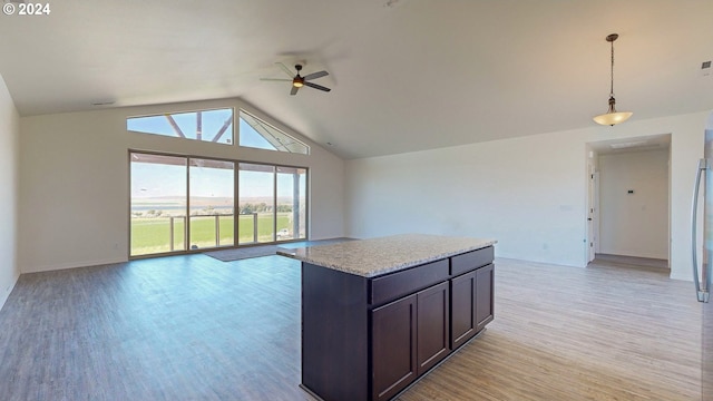 kitchen featuring vaulted ceiling, ceiling fan, light hardwood / wood-style floors, a kitchen island, and hanging light fixtures