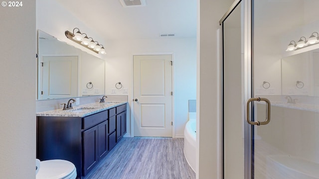 full bathroom with hardwood / wood-style flooring, vanity, toilet, and shower with separate bathtub