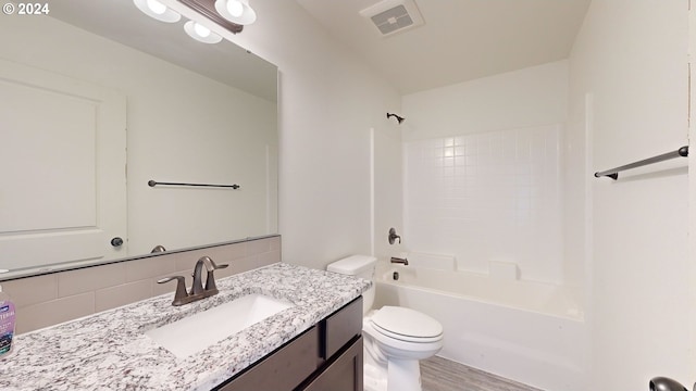 full bathroom featuring tasteful backsplash, tub / shower combination, toilet, vanity, and hardwood / wood-style flooring