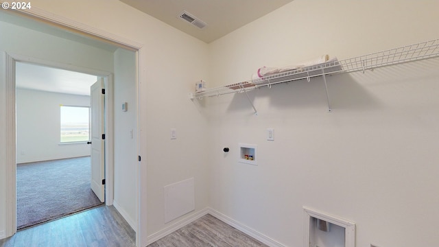 washroom with washer hookup, light wood-type flooring, and electric dryer hookup