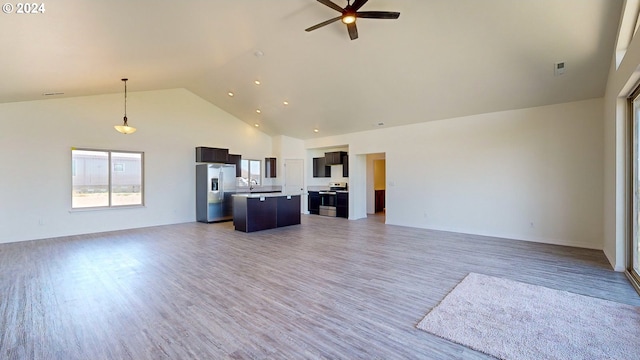 unfurnished living room with ceiling fan, hardwood / wood-style floors, high vaulted ceiling, and sink