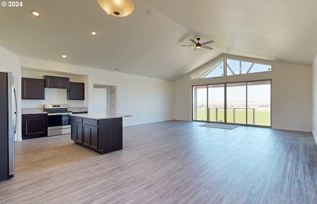 kitchen with a center island, light hardwood / wood-style floors, lofted ceiling, dark brown cabinets, and appliances with stainless steel finishes