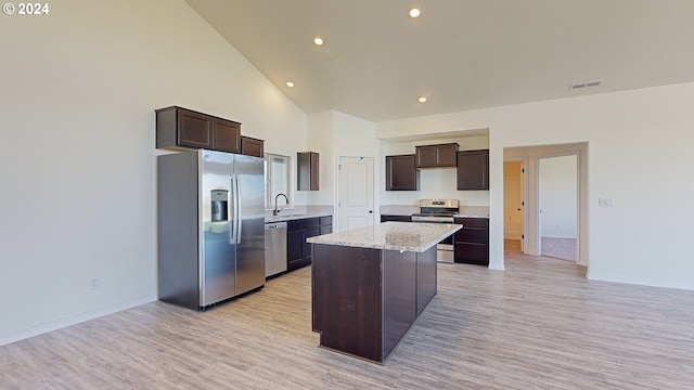 kitchen with dark brown cabinetry, a kitchen island, high vaulted ceiling, and appliances with stainless steel finishes