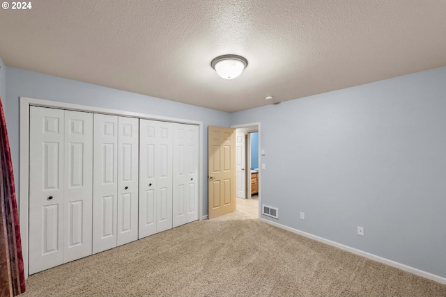 unfurnished bedroom with a closet, a textured ceiling, and carpet