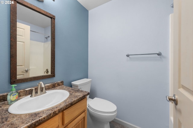 bathroom featuring vanity, toilet, and walk in shower