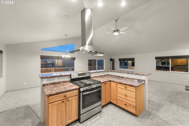 kitchen featuring wall chimney range hood, hanging light fixtures, light carpet, vaulted ceiling, and stainless steel range with gas cooktop