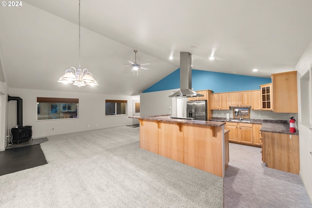 kitchen featuring island exhaust hood, a wood stove, a kitchen breakfast bar, light carpet, and stainless steel fridge with ice dispenser