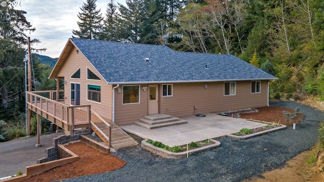 rear view of house featuring a patio and a wooden deck