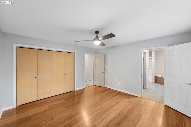 unfurnished bedroom with a closet, ensuite bath, light wood-type flooring, and ceiling fan