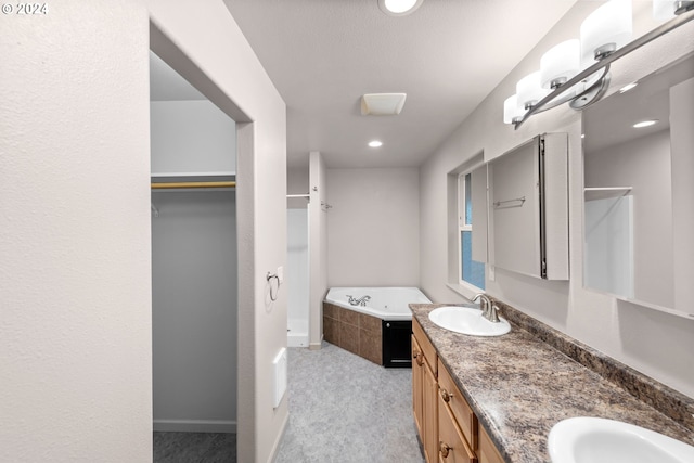 bathroom featuring vanity and a relaxing tiled tub