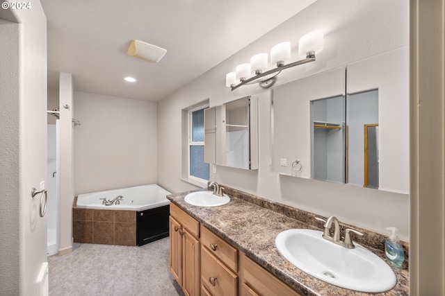 bathroom with vanity and tiled tub