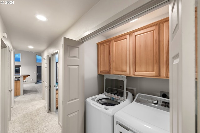 washroom featuring cabinets, light carpet, and separate washer and dryer