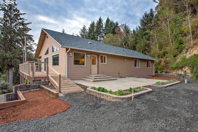 rear view of property with a patio and a wooden deck