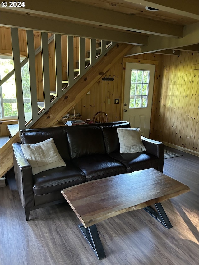 unfurnished living room with hardwood / wood-style flooring, wood walls, and beamed ceiling