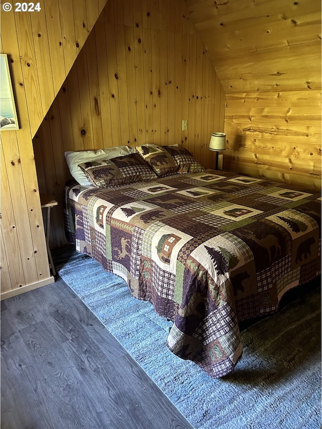 unfurnished bedroom with wood walls, dark hardwood / wood-style flooring, and vaulted ceiling