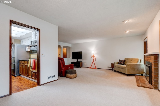 carpeted living room featuring a textured ceiling and a brick fireplace