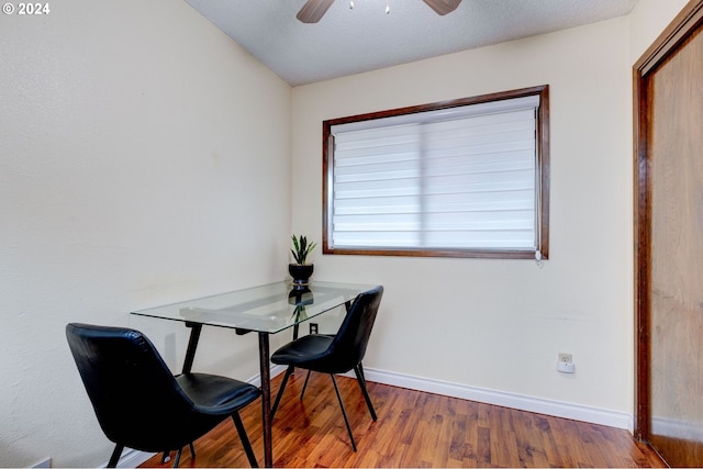 dining room featuring hardwood / wood-style floors, ceiling fan, and a textured ceiling