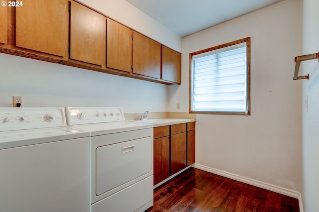 laundry room featuring washing machine and clothes dryer, dark wood-type flooring, cabinets, and sink