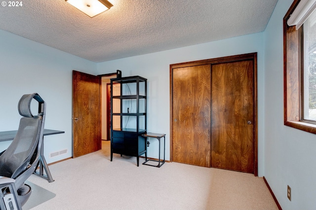 office space with light carpet and a textured ceiling