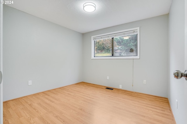 empty room featuring light hardwood / wood-style flooring and a textured ceiling