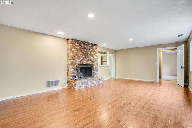 unfurnished living room featuring a fireplace and light hardwood / wood-style flooring