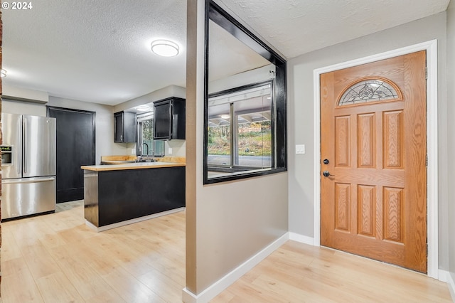 entryway featuring light hardwood / wood-style floors, sink, and a textured ceiling