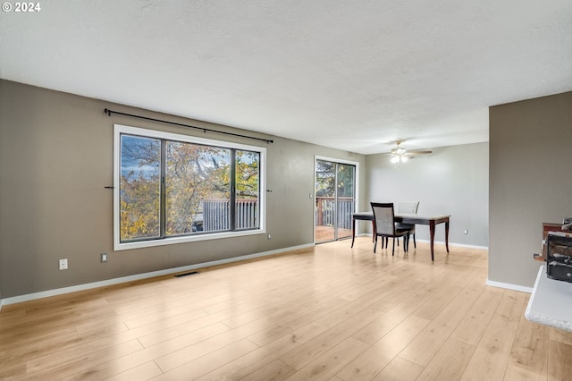 interior space featuring a textured ceiling, light hardwood / wood-style floors, and ceiling fan