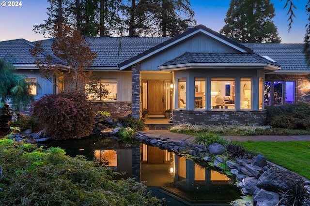 view of front of property featuring a tiled roof and brick siding