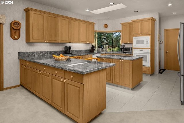 22750 SW Rosedale Rd, Beaverton, OR 97078 - kitchen featuring a skylight, a peninsula, a center island, white appliances, and a toaster