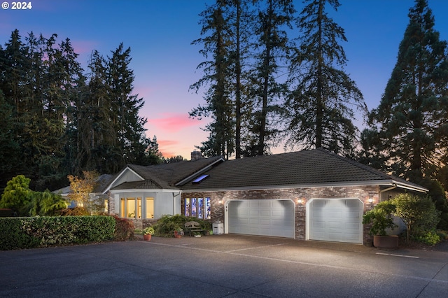 single story home featuring an attached garage, driveway, and a tiled roof