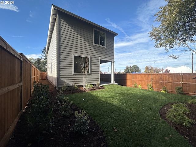 rear view of property featuring a lawn