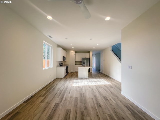 unfurnished living room with light hardwood / wood-style flooring and ceiling fan