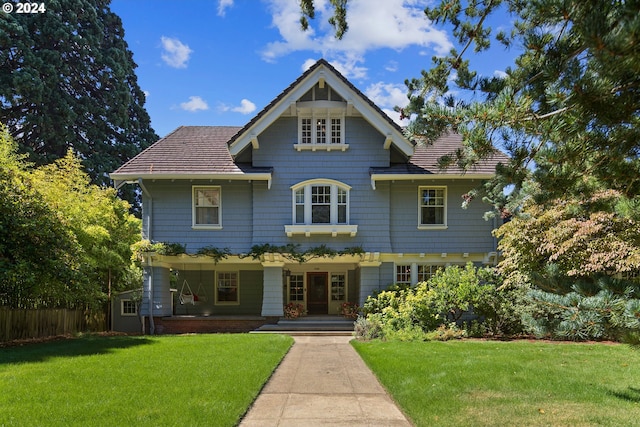 view of front of house with a front yard and fence