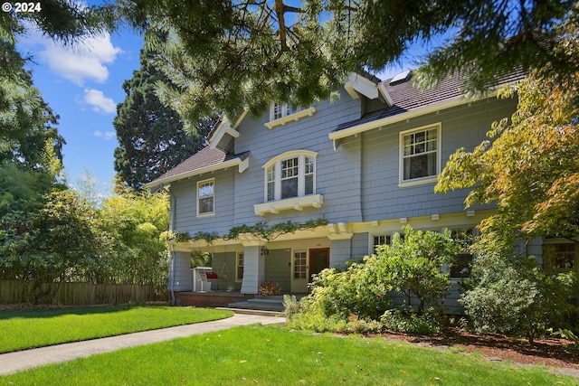 view of front of home featuring a porch, a front yard, and fence